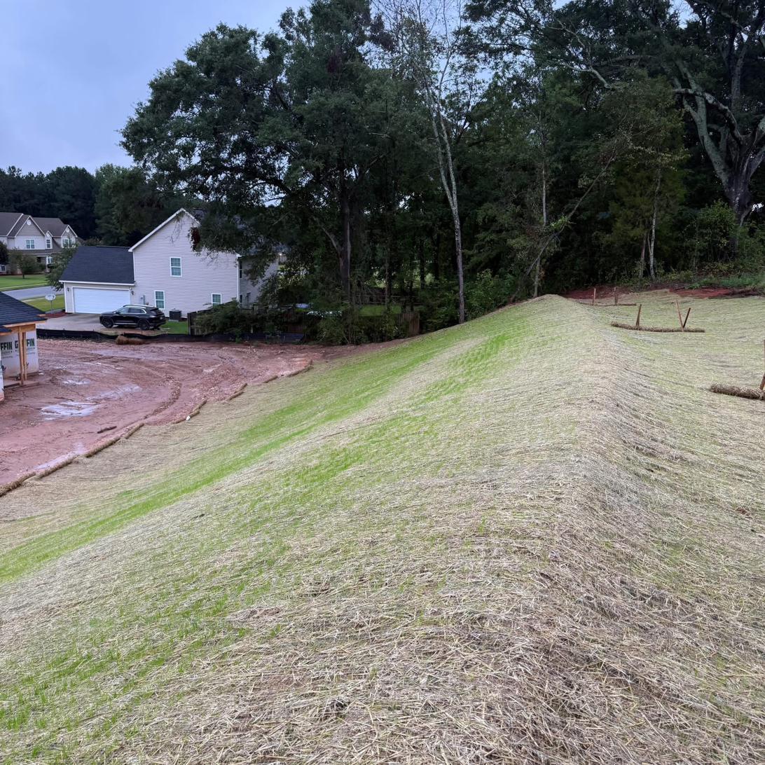 Stable Slopes ECS crew installing erosion control matting on a residential hillside in Georgia