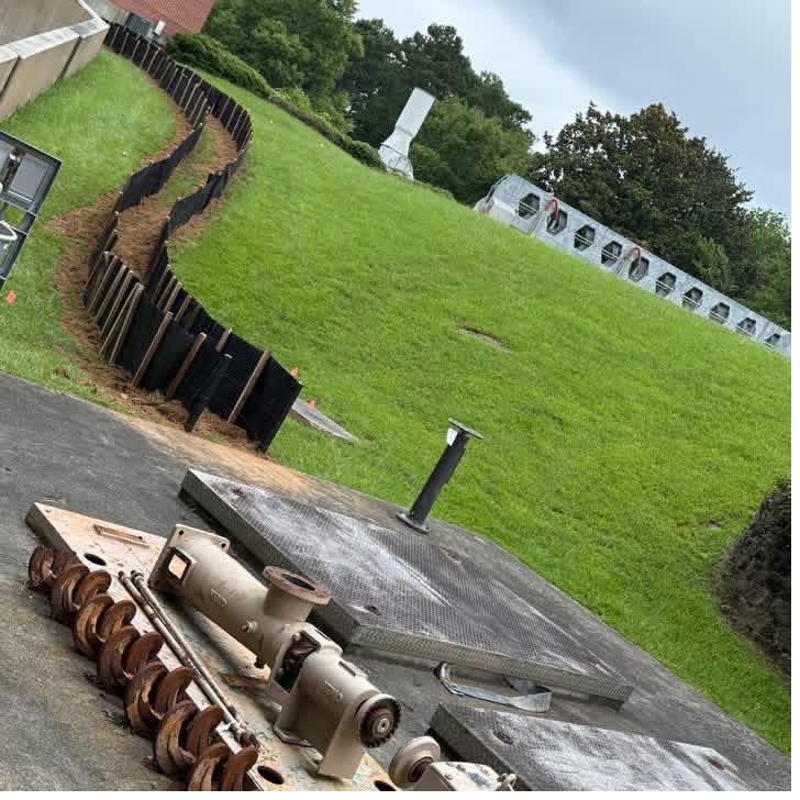 Curving silt fence and erosion control matting installed along a graded slope in Georgia